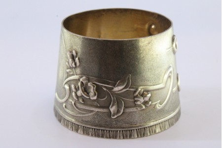 Argola de guardanapo em prata em forma de punho e relevada com motivos florais.